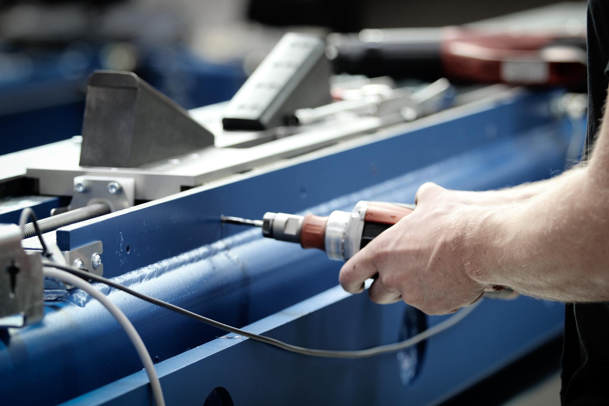 Ein Facharbeiter bohrt ein Loch in eine Metallvorrichtung